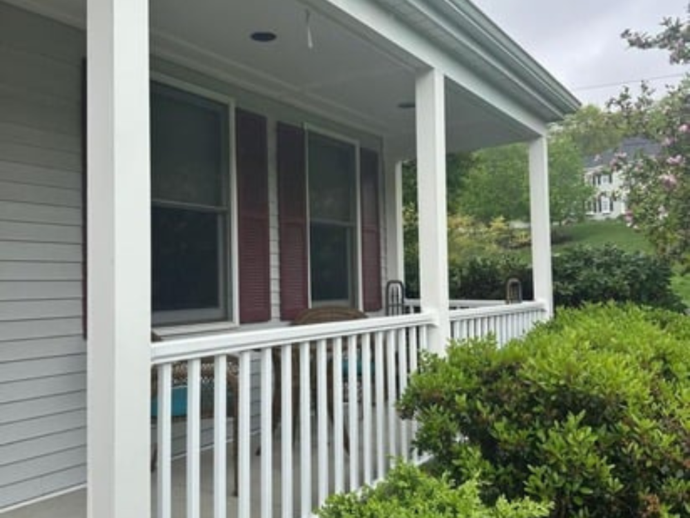 Front porch after broken railings replacement in Franklin MA, showing new white railings and restored ceiling.