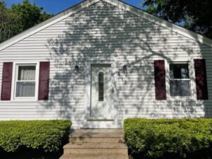 Power washing Uxbridge – Back exterior wall of a house with visible dirt and mildew on the lower siding, ideal for pressure cleaning services.