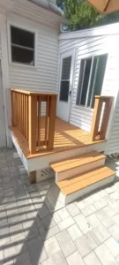 Small entry deck transformation with new wood steps and railings.