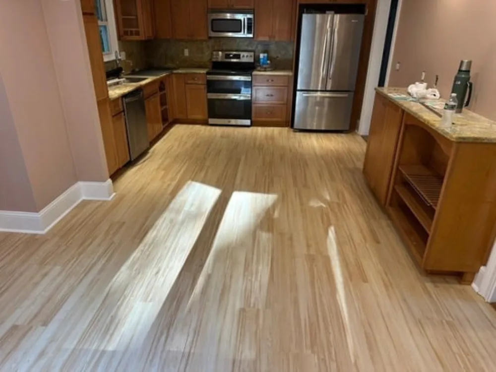 Completed kitchen floor renovation with new vinyl planks.