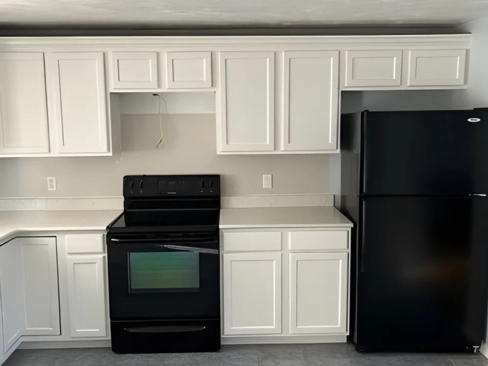 cabinets painting Uxbridge Ma completed kitchen with white cabinets and black appliances